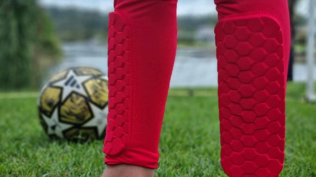 Alpha Skins red shin guards with soccer ball in backgroung