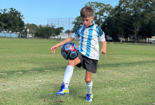 Jax juggling a soccer ball wearing a pair of white alpha skins shin pads whislt training at Palm Beach Soccer Fields