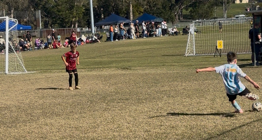 "Jax from Palm Beach Sharks U10 Blue taking a sideline free kick during the 2026 Gold Coast United Cup at Coplick Family Sports Park"